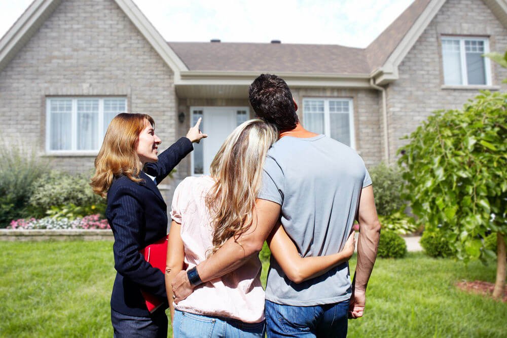 Female property sourcer showing a house to a couple