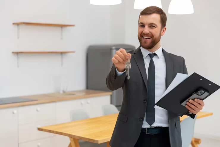 Professional property agent holding keys and documents for buy-to-rent investment services