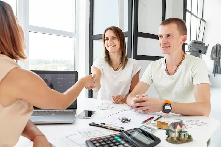 Property professionals shaking hands over hidden opportunity investment deal with documents and calculator